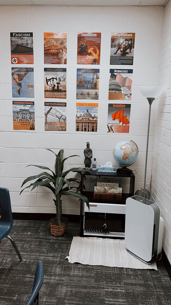 a room with posters on the wall and a chair next to it, in front of a desk