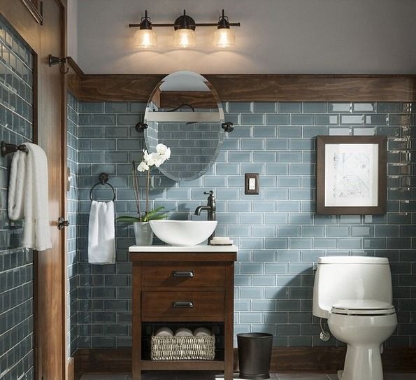 a bathroom with a toilet, sink and mirror on the wall in front of it