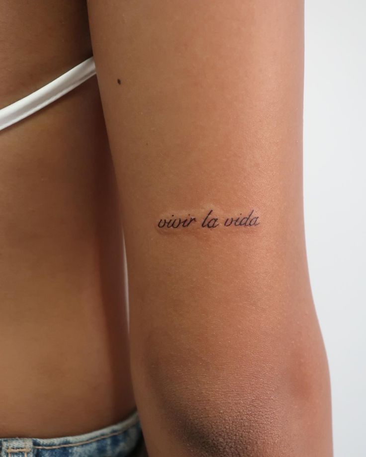 a woman with a tattoo on her arm saying, never to write in cursive writing