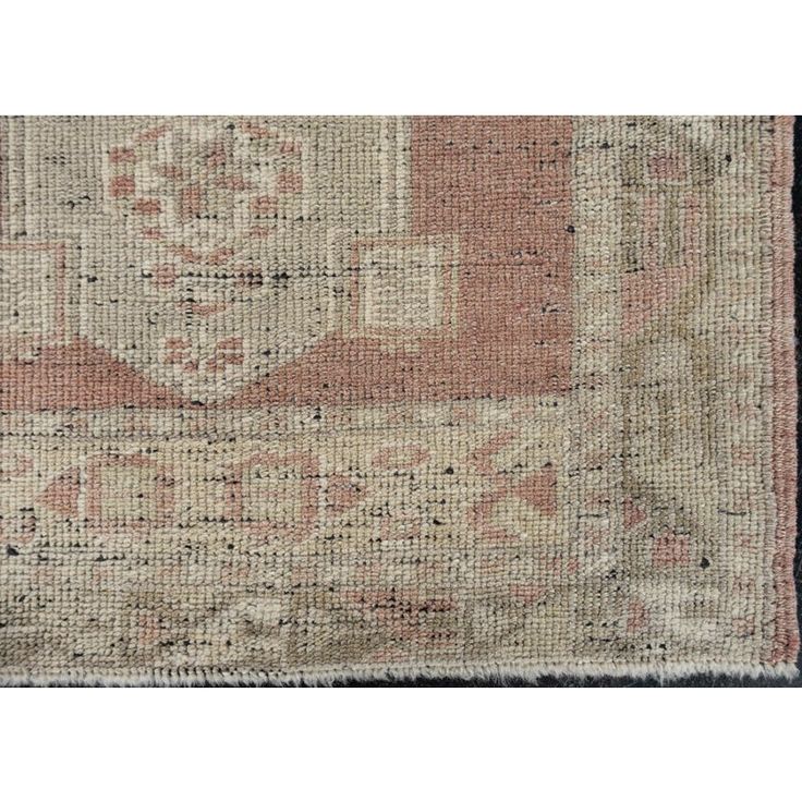 an antique rug with pink and beige colors