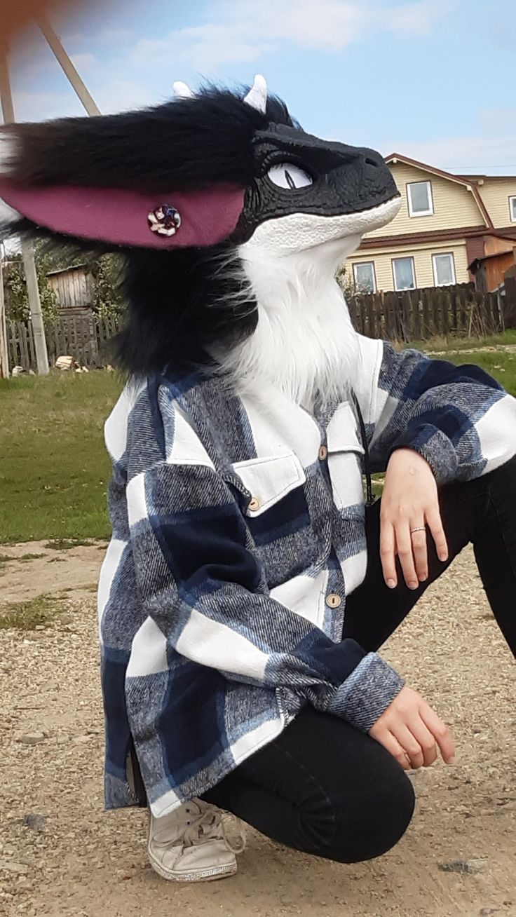 a person sitting on the ground with a stuffed animal in front of their face and hands