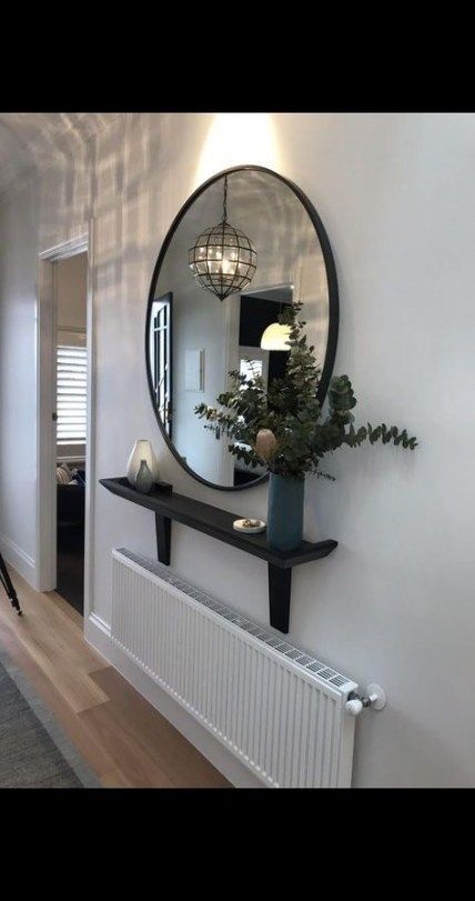 a mirror hanging on the wall above a radiator