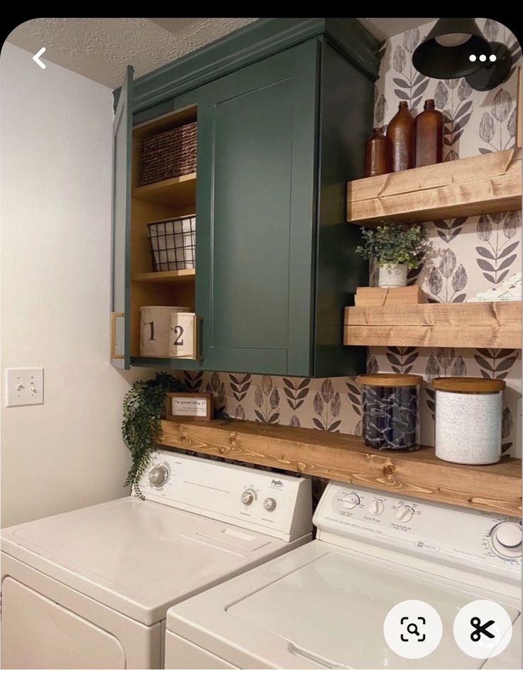 a washer and dryer sitting next to each other in a room with shelves on the wall