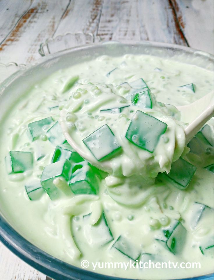 a glass bowl filled with green jello and ice cream