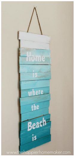 a wooden sign that says home is where the beach is hanging on a wall in a room