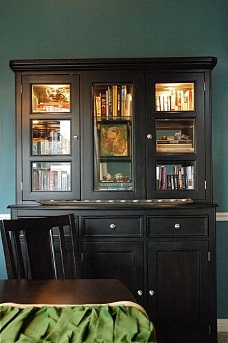 a dining room with green walls and wooden furniture