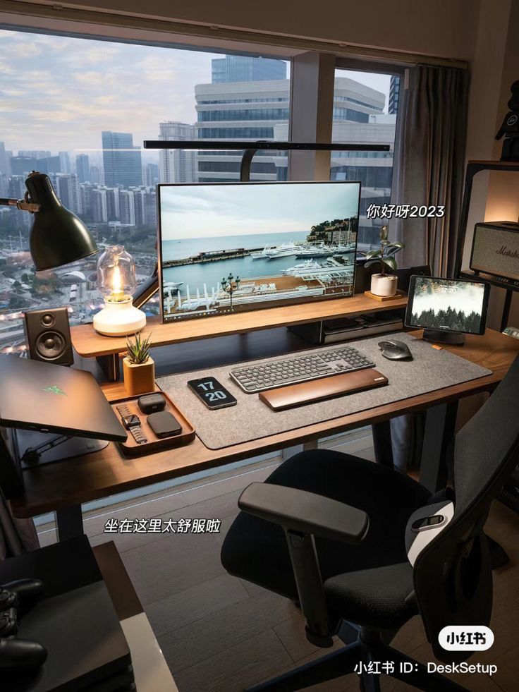 a desk with a computer monitor, keyboard and mouse on it in front of a window