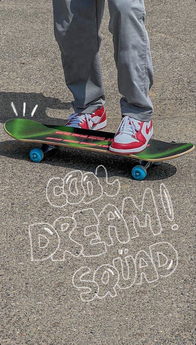 a person standing on top of a skateboard with chalk writing in front of them