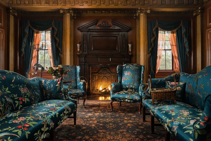 a living room filled with blue couches and chairs in front of a fire place