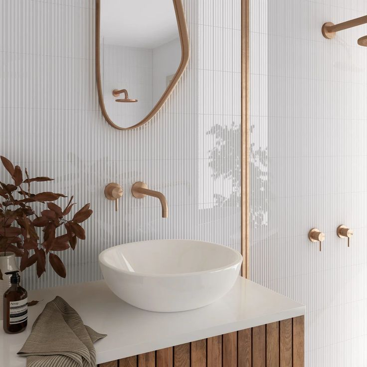 a white sink sitting on top of a counter next to a mirror and towel rack