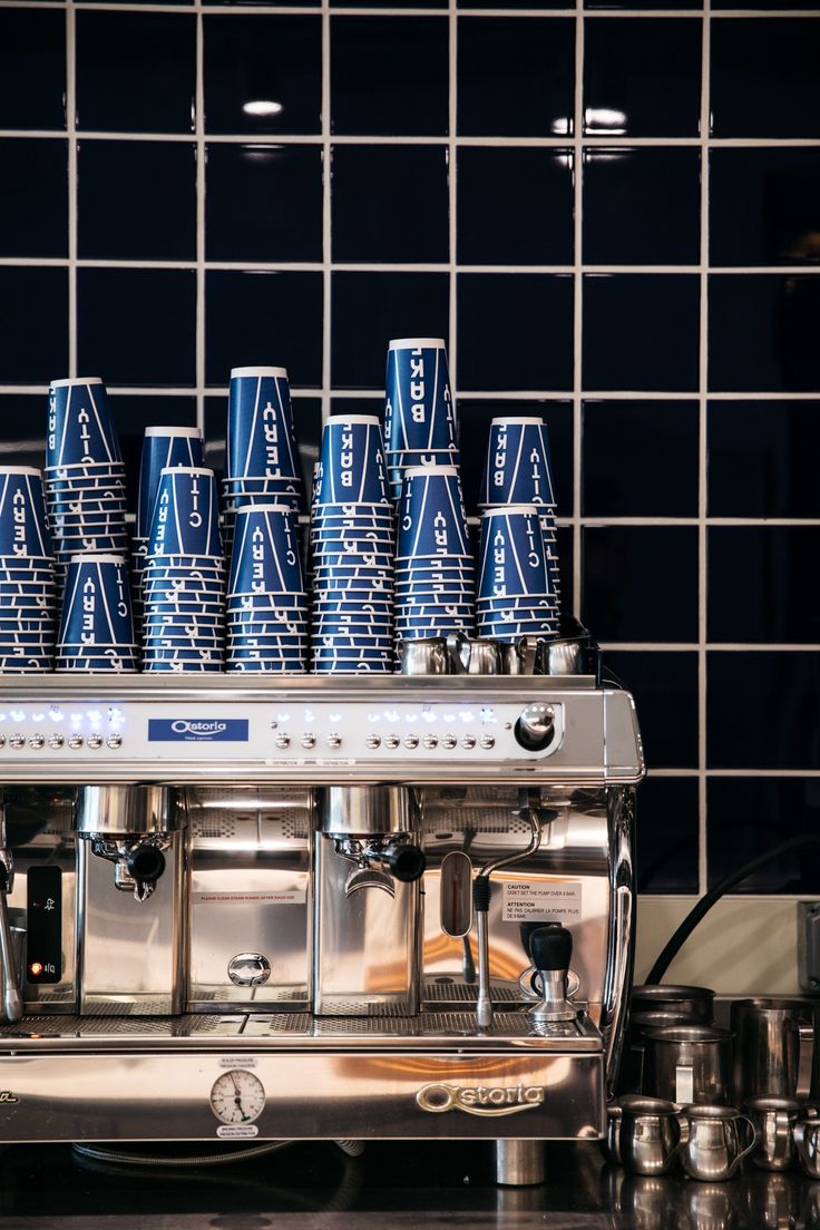 several blue cups sitting on top of a coffee machine