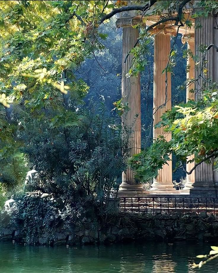 an old building sitting on top of a river next to tall pillars with columns in the background