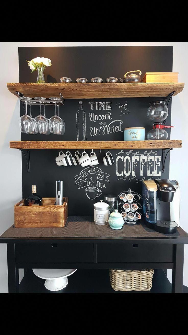 a coffee bar with chalkboard on the wall and wooden shelves holding cups, mugs, glasses, and other items