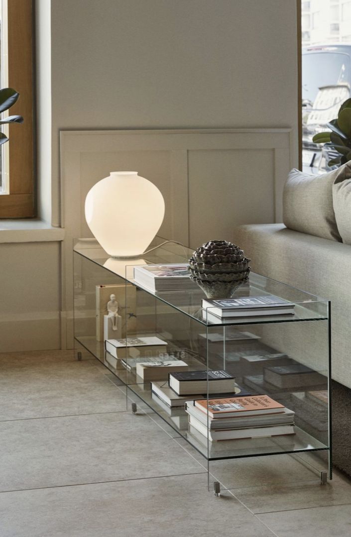 a glass table with books on it in front of a couch