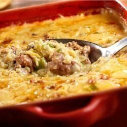 a red casserole dish filled with meat and cheese