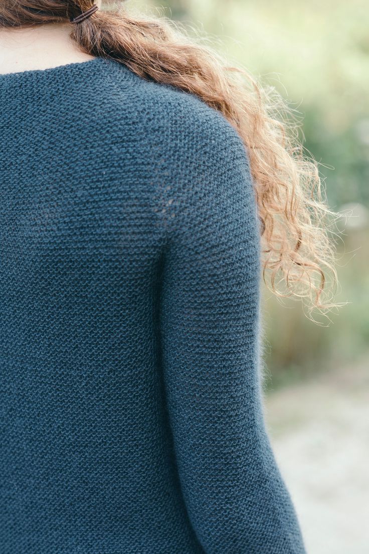 the back of a woman's blue sweater