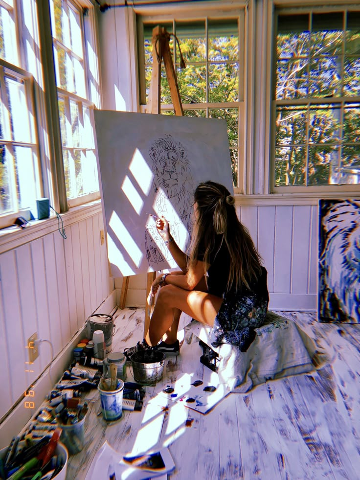 a woman is sitting on the floor painting