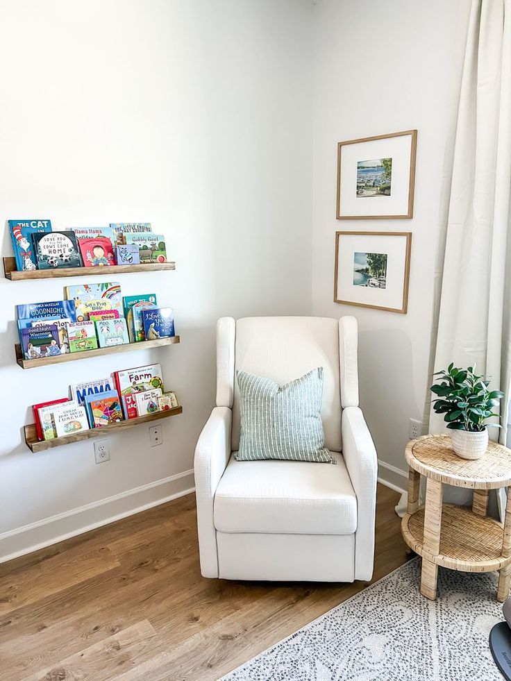 a white chair sitting in a living room next to a book shelf filled with books