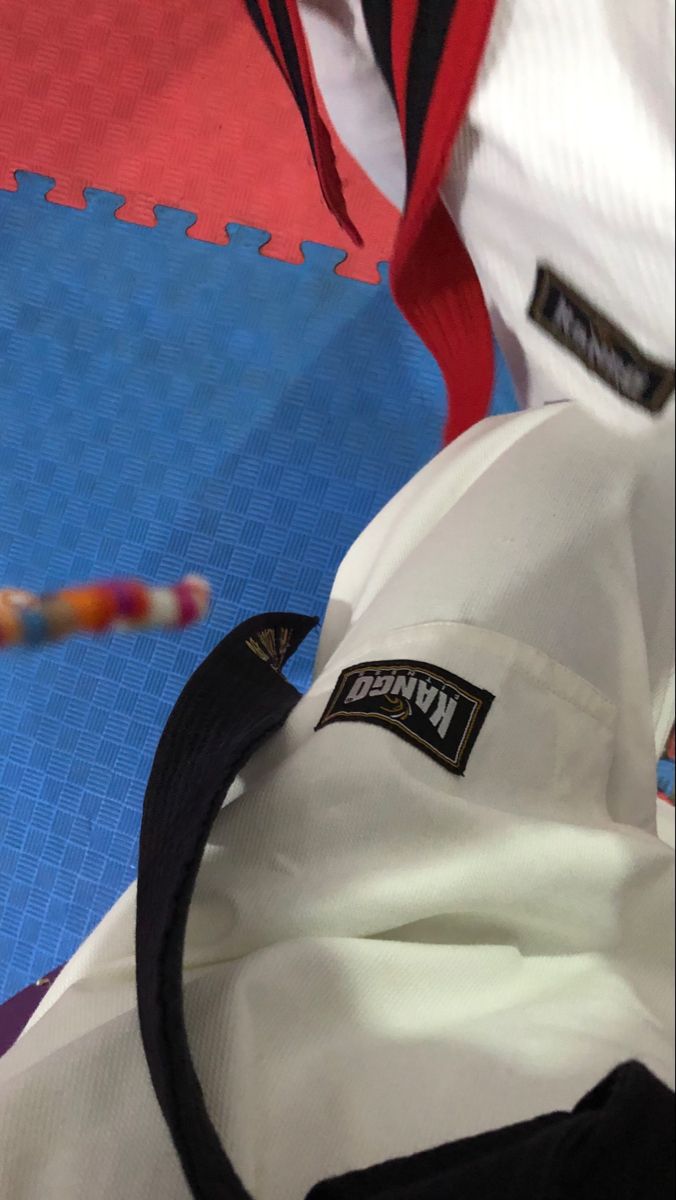 a close up of a person's white shirt and black tie on a blue mat