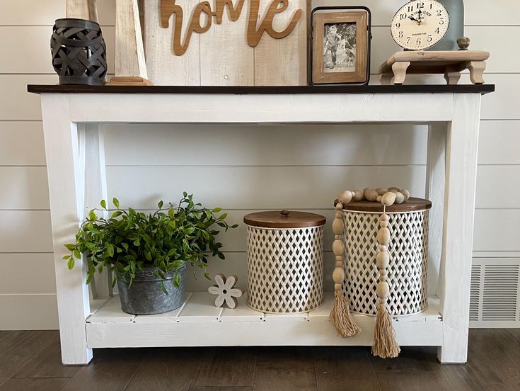 a shelf with some baskets on top of it and other items sitting on the shelves