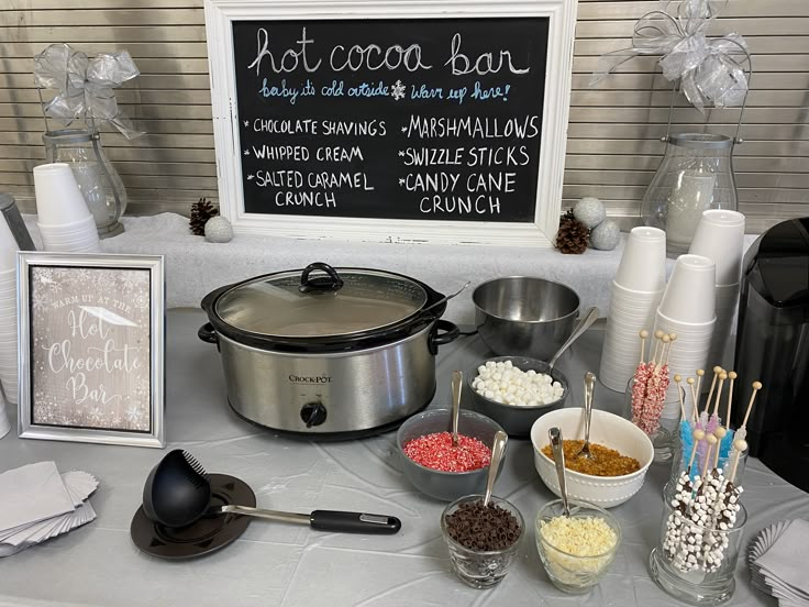 a table topped with lots of food next to a sign that says hot cocoa bar