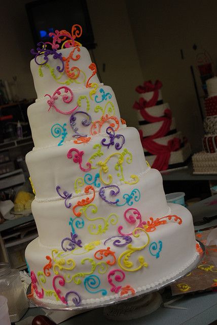 a multi - tiered cake decorated with colorful swirls