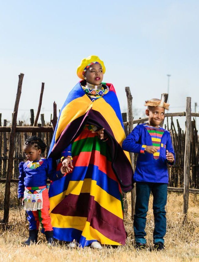 three women dressed in colorful clothing standing next to each other