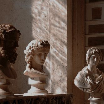 three busturines are sitting in the corner of a room with sunlight streaming through them