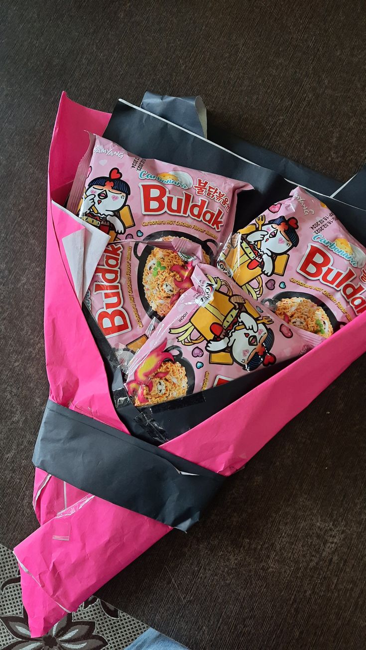 a pink bag filled with snacks sitting on the floor