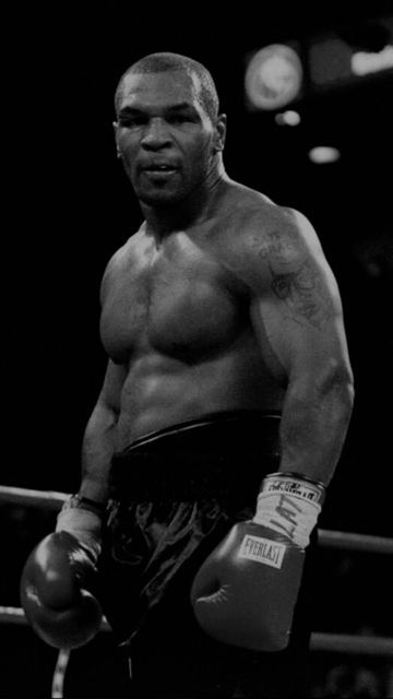 a black and white photo of a man wearing boxing gloves