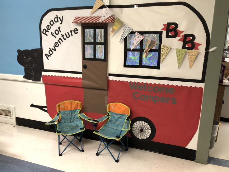 two chairs are sitting in front of a camper themed wall with the words ready for adventure written on it