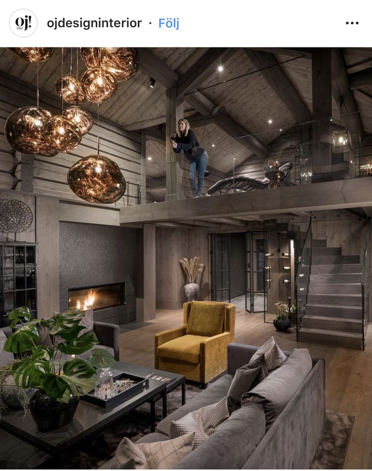 a living room filled with furniture and a fire place in the middle of an open floor plan