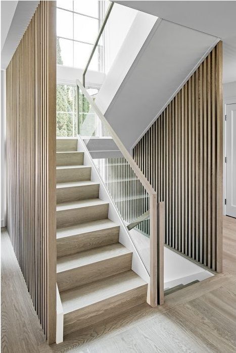 the stairs in this modern house are made from wood and white painted with vertical slats