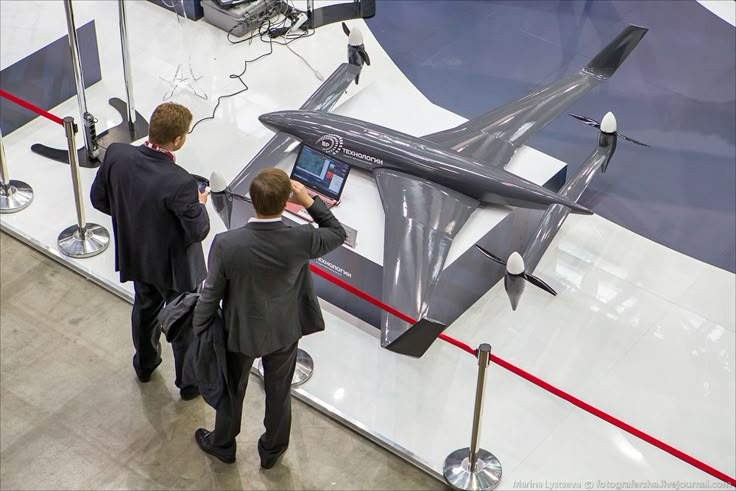 two men looking at an airplane on display