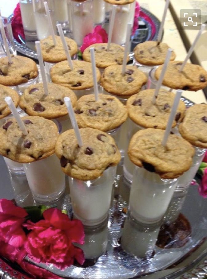 there are many cookies and milkshakes on the tray with toothpicks in them