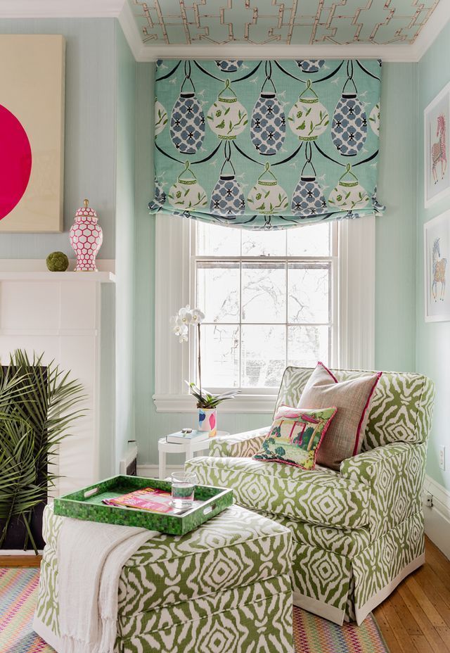 a living room filled with furniture and a window covered in roman shades on the windowsill