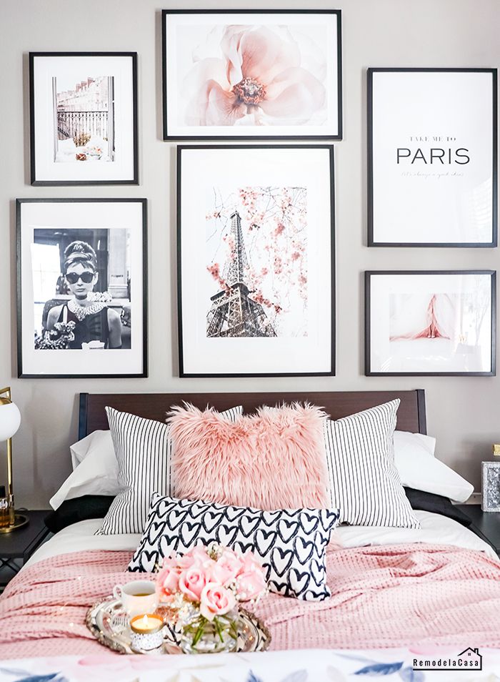 a bed with pink pillows and pictures on the wall