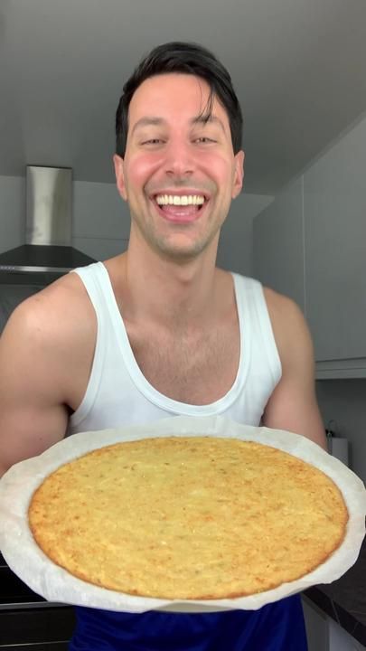 a man holding a large pie on top of a white plate