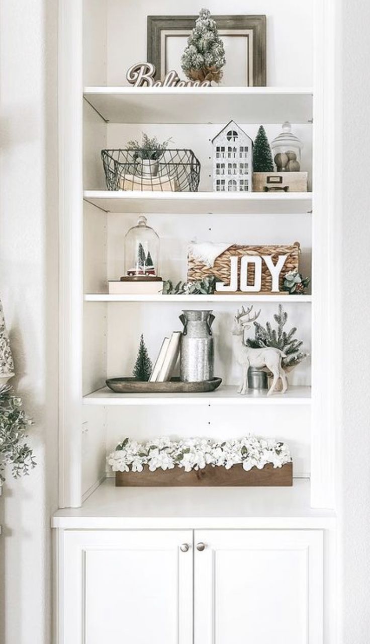 a white book shelf filled with christmas decorations