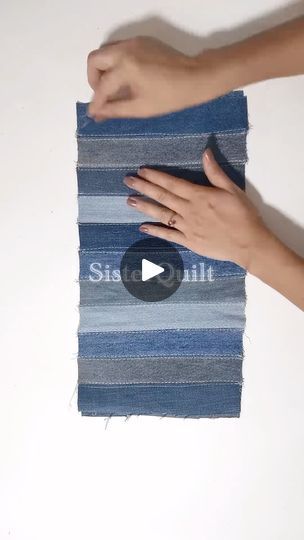 someone is holding onto a blue and gray striped rug with their thumb on the edge