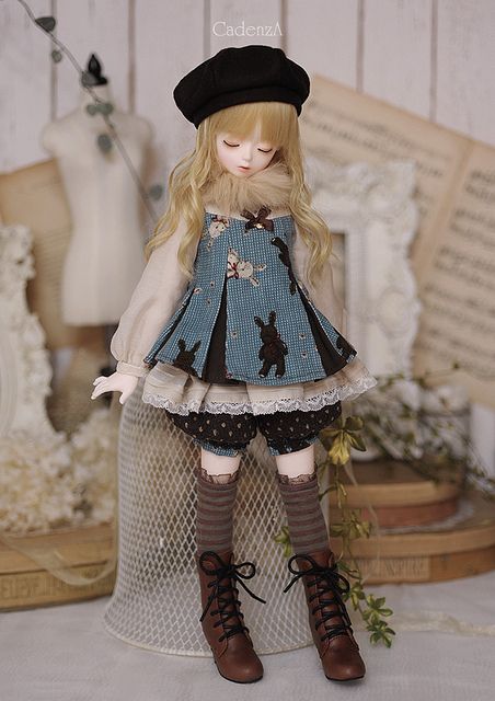 the doll is wearing a dress and hat