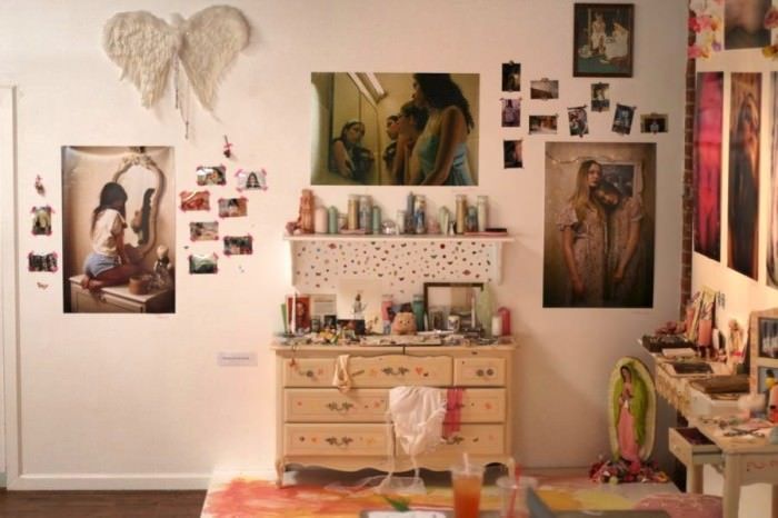 a room filled with lots of clutter and pictures hanging on the wall next to a dresser