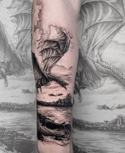 a man's arm with a dragon and boat tattoo on the left side of his leg