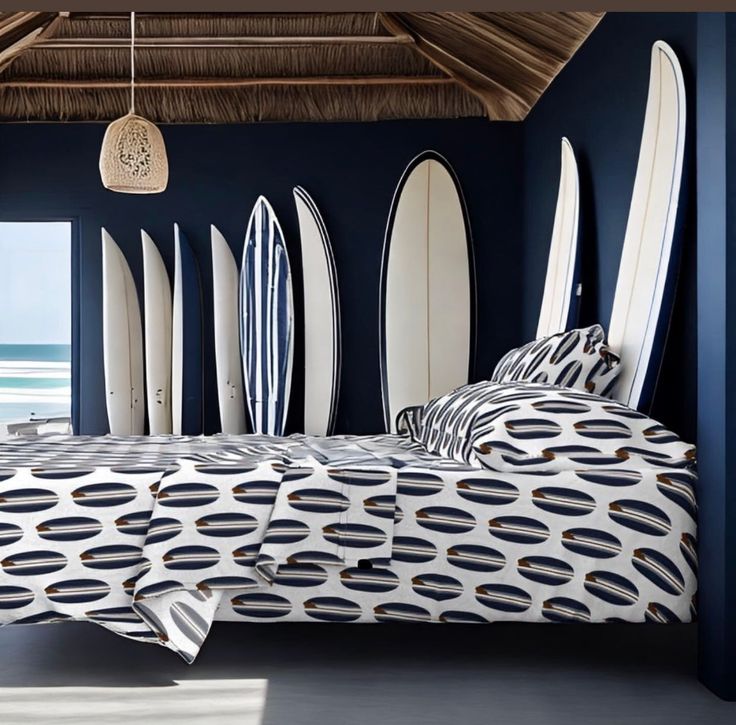 there are many surfboards lined up against the wall in this room, and one bed has been made