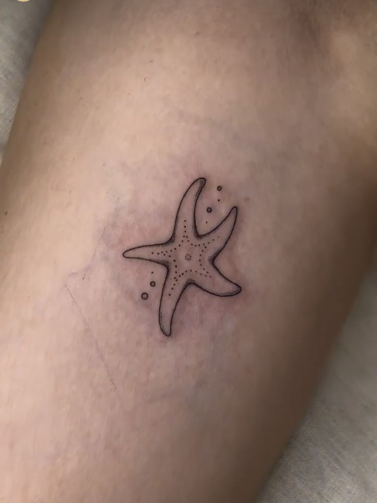 a small starfish tattoo on the leg