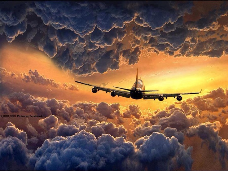 an airplane is flying through the clouds at sunset