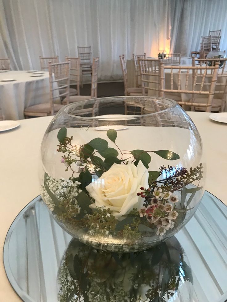 there is a glass bowl with flowers in it