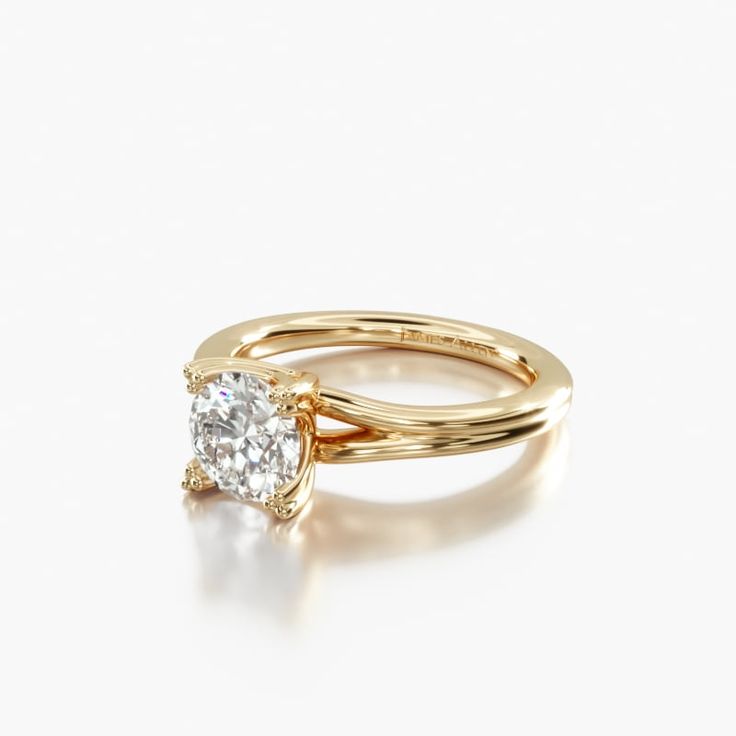 a yellow gold engagement ring with a single diamond in the center, on a white background