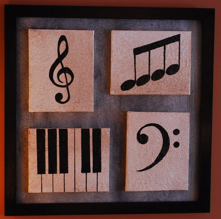 four wooden blocks with musical notes and piano keys on them in a shadow box frame