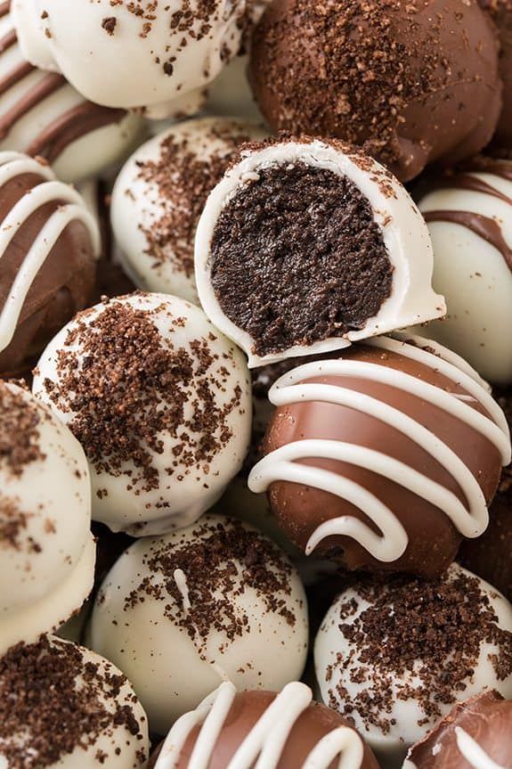 a pile of chocolate truffles with white frosting and sprinkles